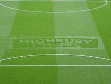 A photograph of a green football turf, with the words Highbury, 1913–2006 etched in the middle.