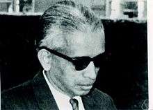 A black and white photograph of man wearing black glasses