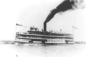 alt=A ship on the water, the stack belching a column of black smoke.